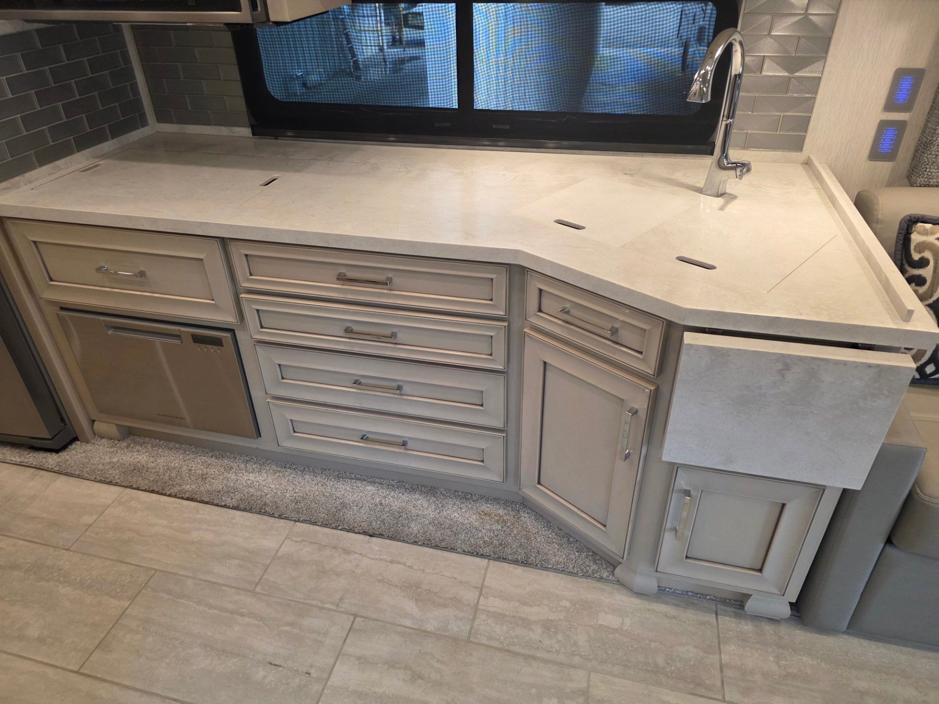 2024 Newmar Super Star 4061 — RV kitchen counter with sink faucet, covered cooking surfaces, drawers, cabinets, and a small appliance below