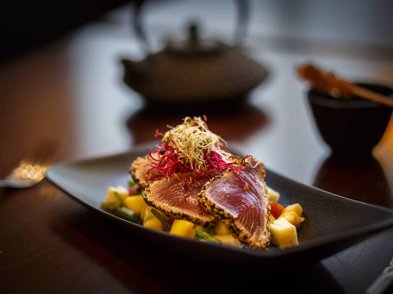 Sesame-crusted tuna slices, served on pineapple-mango salad 🤤🐟