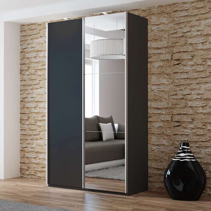The sliding door wardrobe VIGO 120cm black with mirrored door and LED lights in a room.
