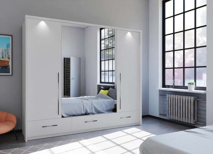 The bi-folding door TOLEDO 255cm Wardrobe white with mirrored doors and LED lights in a cosy bedroom.