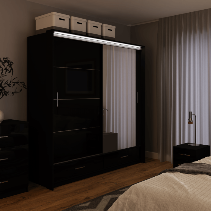 The sliding door wardrobe MARSYLIA 208cm black with mirrored door with LED lighting in a bedroom.