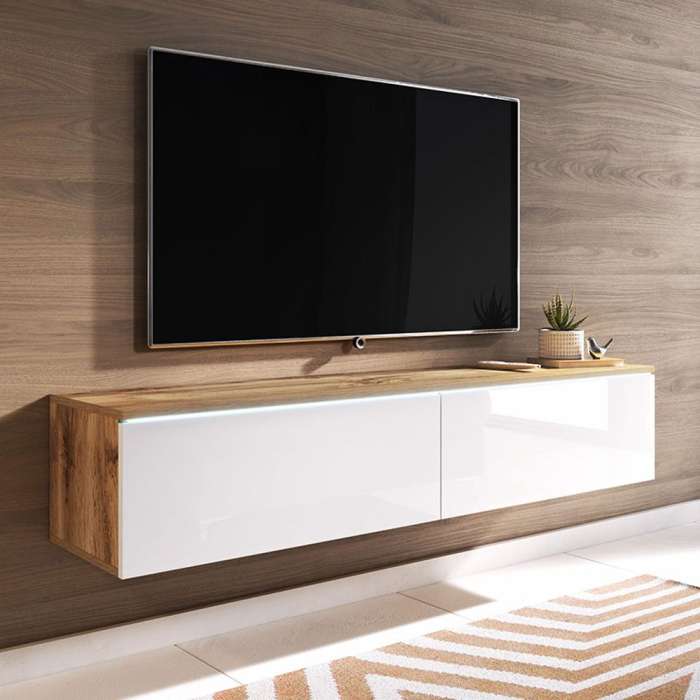 The TV unit DAISY 140 wotan oak with white glossy fronts in a modern living room.