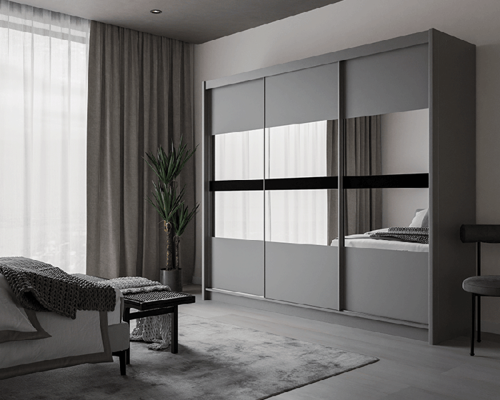 The sliding door wardrobe BATUMI 250cm graphite with mirrored doors in a cosy bedroom.