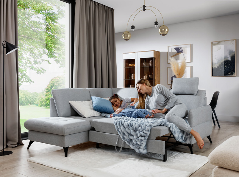 The corner sofa bed LUKAS presenting a sleeping area in a beautiful living room.