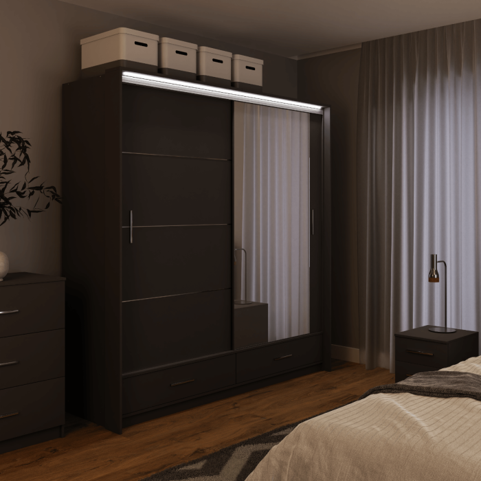The sliding door wardrobe MARSYLIA 208cm graphite with mirrored door with LED lighting in a bedroom.