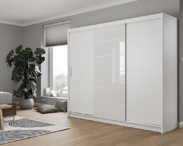 The sliding door wardrobe MALIBU white in a cosy bedroom.