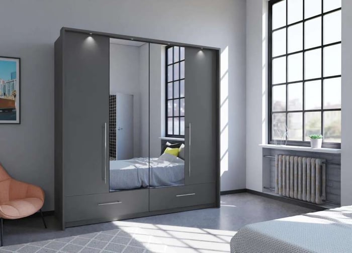 The bi-folding door TOLEDO 210cm Wardrobe graphite with mirrored doors and LED lights in a cosy bedroom.