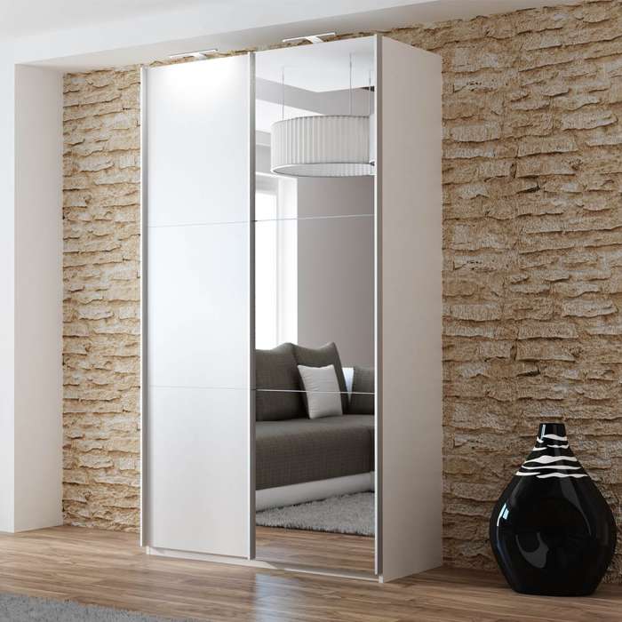 The sliding door wardrobe VIGO 120cm white with mirrored door and LED lights in a room.