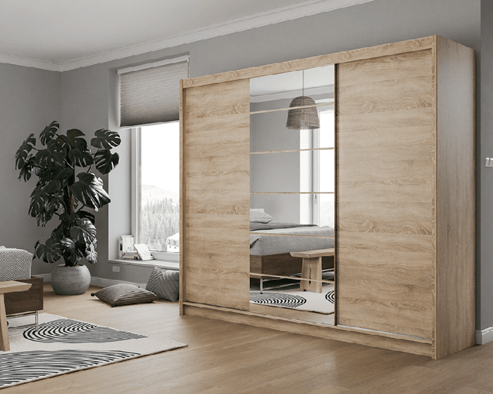 The sliding door wardrobe MALIBU oak sonoma with mirror in a cosy bedroom.