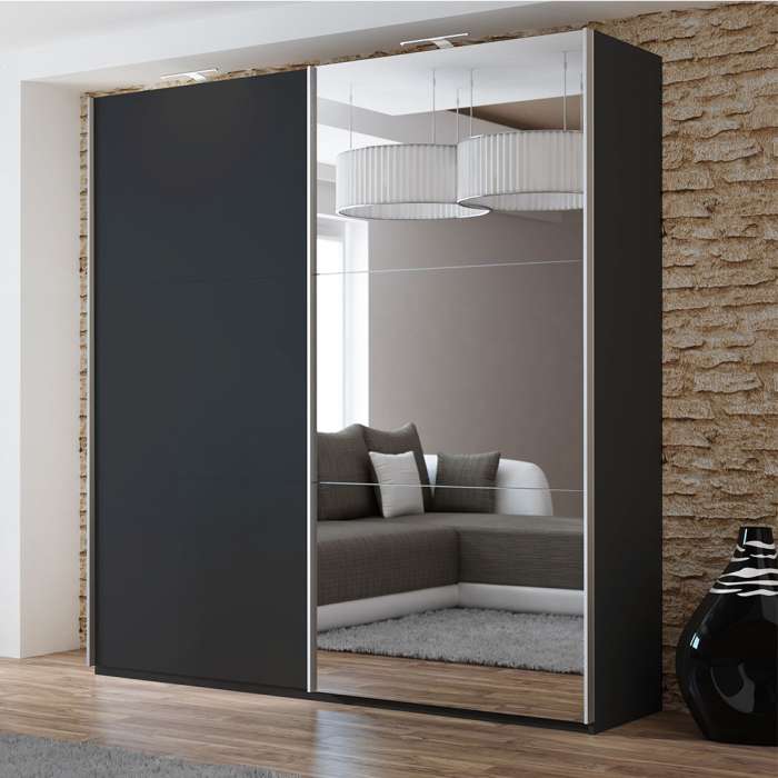 The sliding door wardrobe VIGO 200cm black with mirrored door and LED lights in a room.