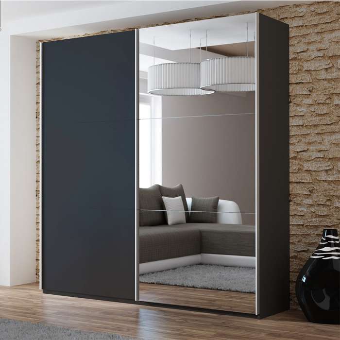 The sliding door wardrobe VIGO 200cm white with mirrored door in a room.