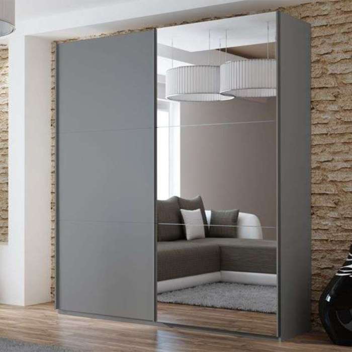 The sliding door wardrobe VIGO 200cm graphite with mirrored door in a room.