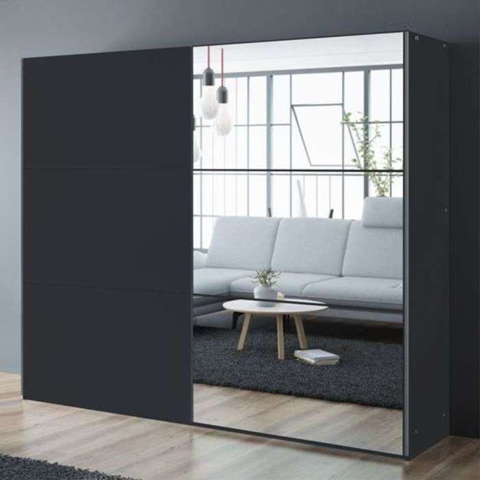 The sliding door wardrobe VIGO 250cm black with mirrored door in a room.