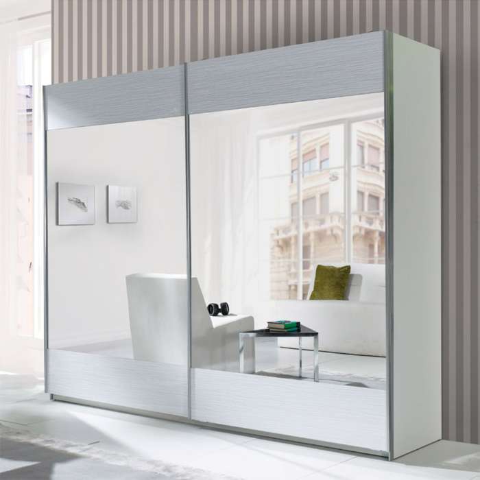 The sliding door wardrobe LUX STRIPES white with mirrored doors in a bedroom.