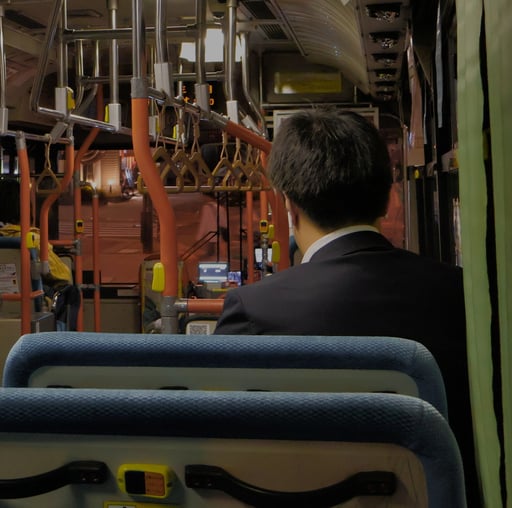 a young salaryman on the bus late at night