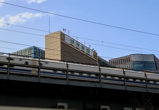 many japanese trains travel over motor and pedestrian roads on bridges like this