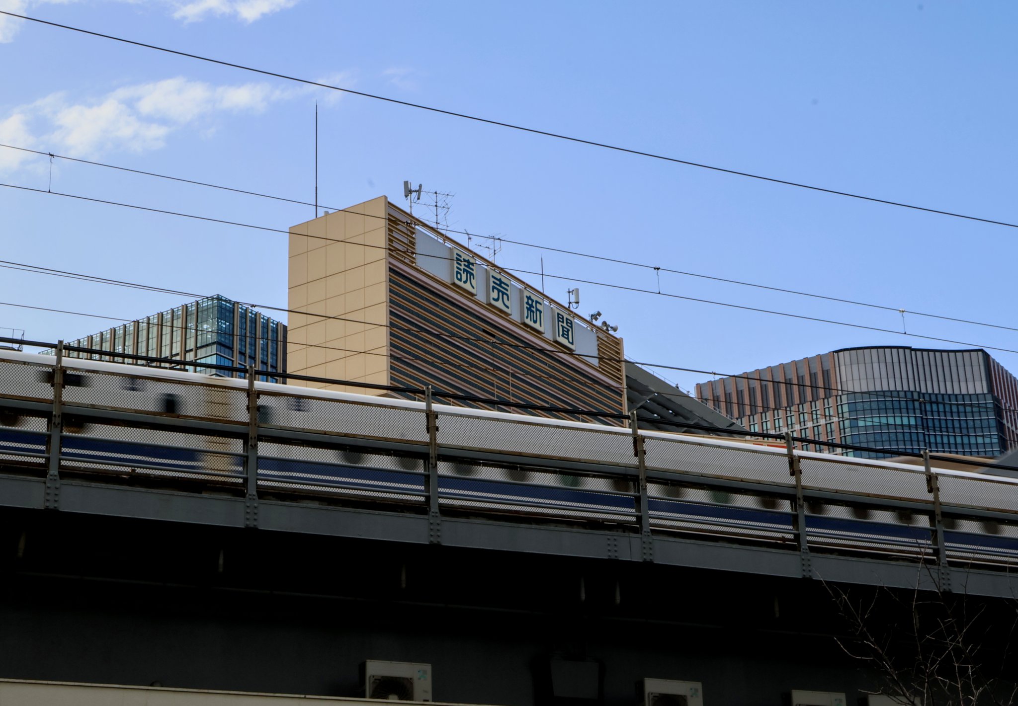 many japanese trains travel over motor and pedestrian roads on bridges like this