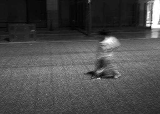 a brown kid by himself on a japanese pedestrian street