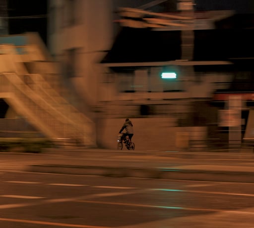 a guy biking through the rain late at night