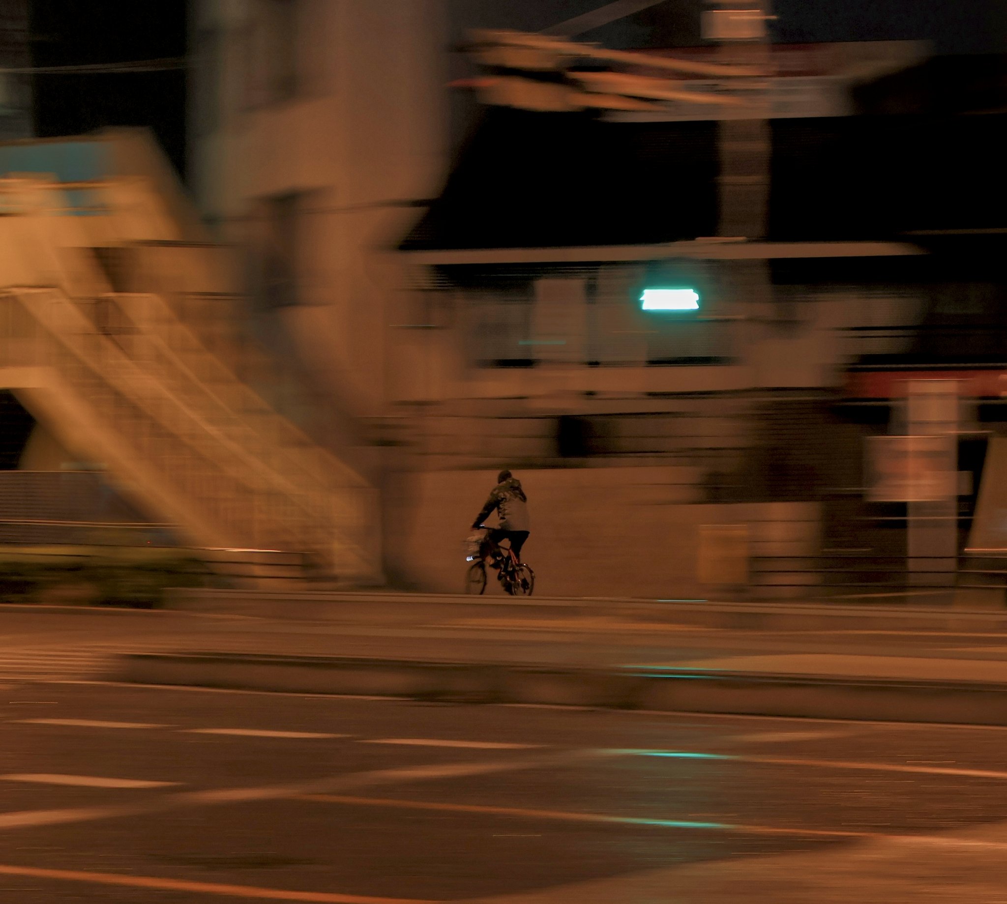 a guy biking through the rain late at night