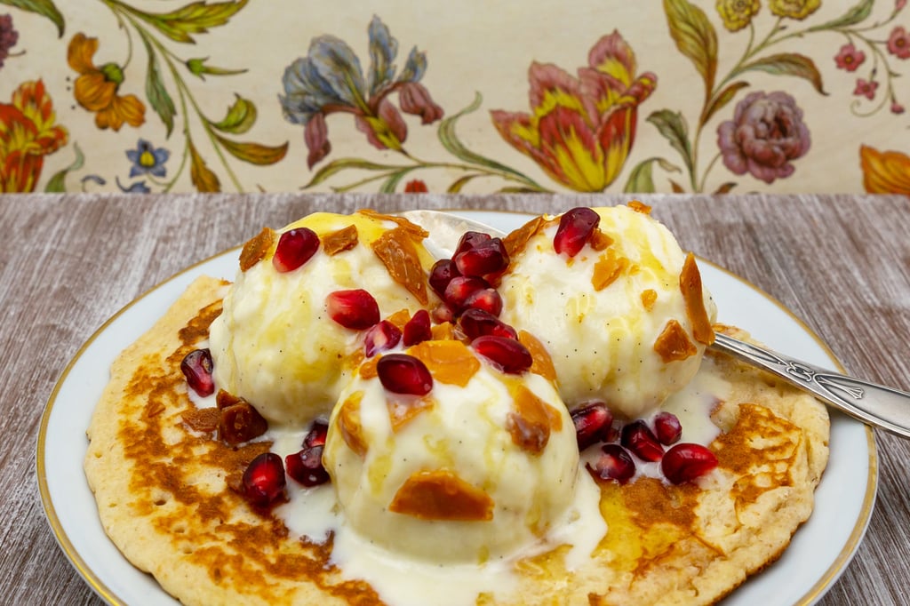 Cremoso helado de anacardos sobre tortita con nueces caramelizadas, miel y granos de granada.
