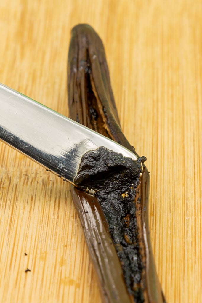 Scrape the vanilla pulp out of the pod with a spoon handle. The picture shows a special vanilla pod (Vanille bleue), therefore the pulp appears very moist.