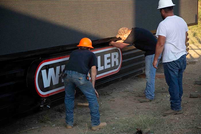 installing Whistler Billboard's logo on the billboard structure before lifting onto structure