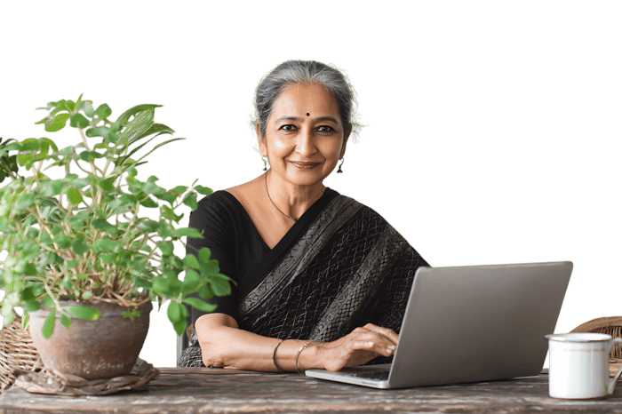 Smiling senior woman using laptop, plants nearby