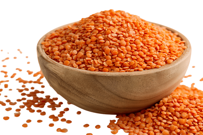 Red lentils in a wooden bowl, close up.