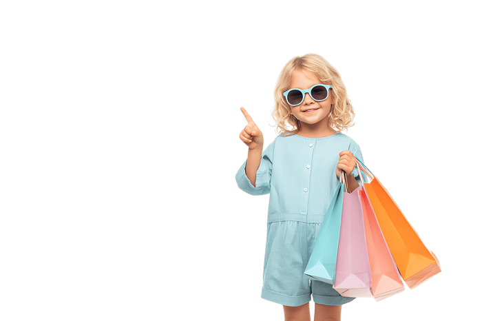 Adorable toddler girl with shopping bags, pointing upwards.