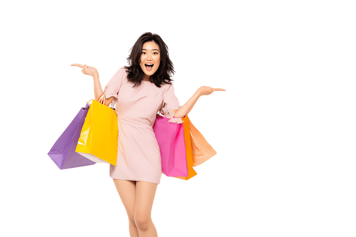 Excited woman with shopping bags, showing off purchases.