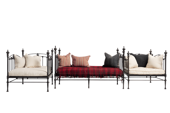 Three black metal daybeds with different colored cushions.