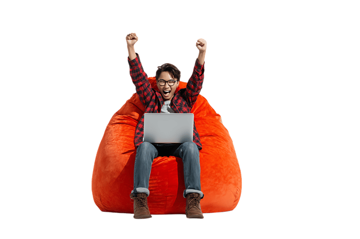 Excited man celebrates success on laptop in beanbag chair