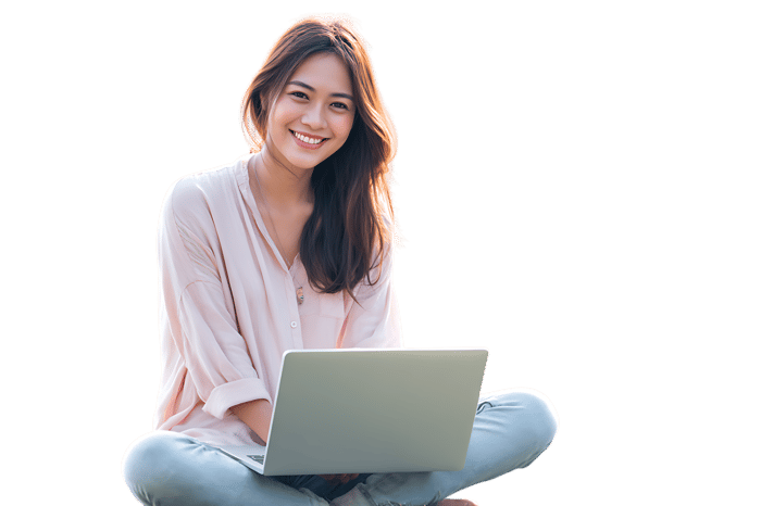 Smiling woman working on laptop outdoors.