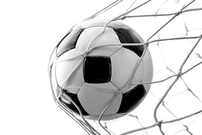 Soccer ball in goal net, black and white
