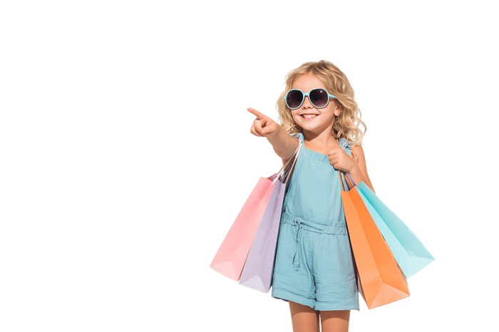 Smiling child with shopping bags, pointing towards something.