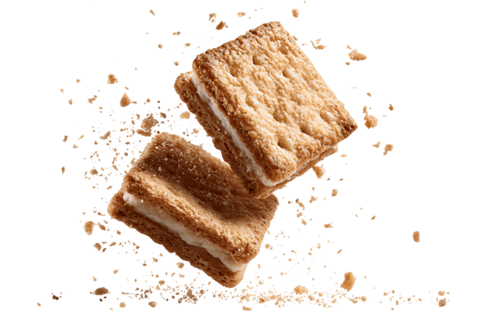Two delicious sandwich cookies in mid air, crumbs flying.