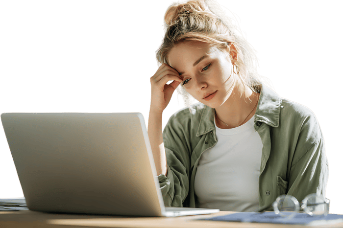 Tired woman working on laptop, feeling stressed.