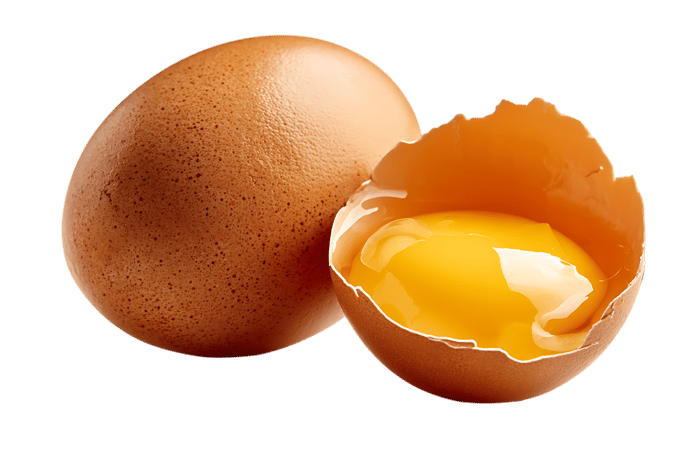 One whole and one cracked open brown egg revealing a vibrant yolk.