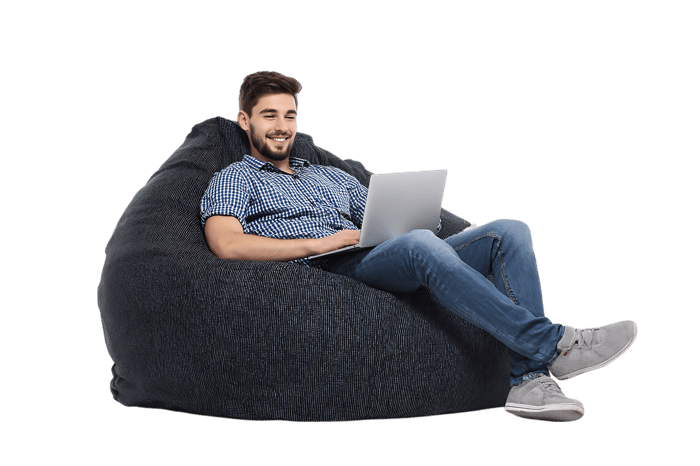 Comfortable man working on laptop in a bean bag chair.