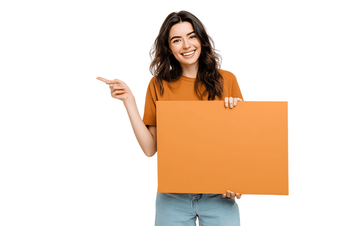 Smiling girl pointing at blank orange sign, isolated on black background812.