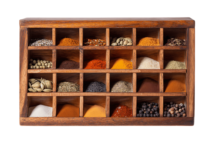Wooden spice box with various spices.