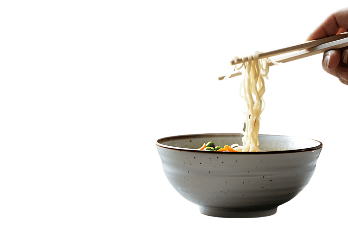 Close up of chopsticks lifting noodles from a bowl.