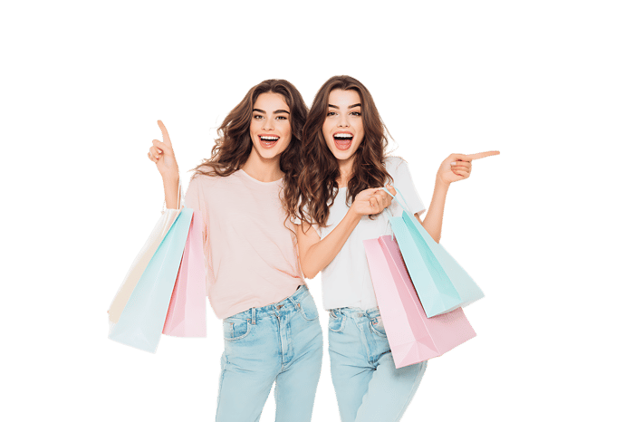 Two happy women with shopping bags, pointing directions. Sales, discounts, retail concept.