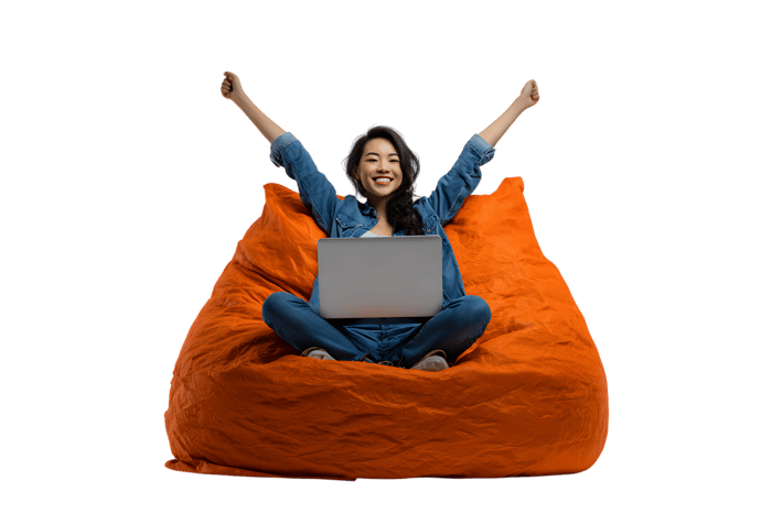 Joyful young woman celebrating success while working from home in a comfortable beanbag chair