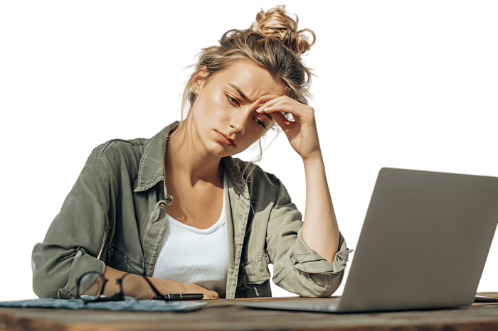 Young woman feeling stressed while working on her laptop outdoors.
