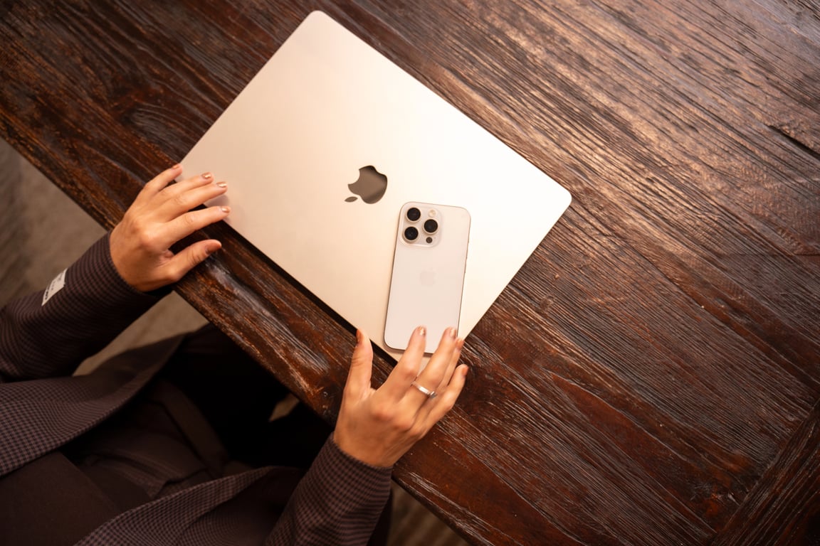 Team collaboration with laptops and tablets around a wooden table
