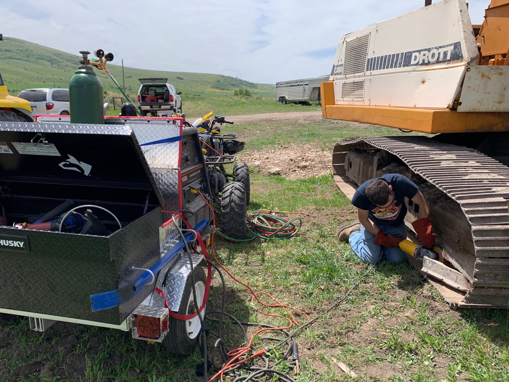Jimmie grinding on an excavator, with his mobile welding rig providing the power