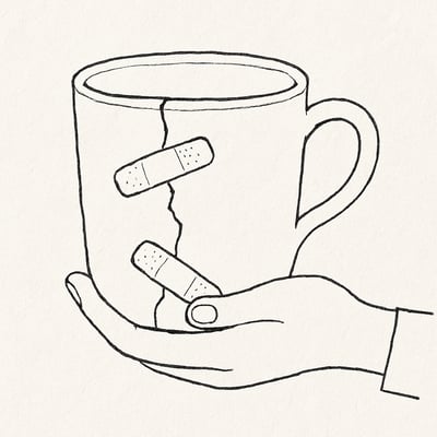 A cracked coffee mug steadied by a hand and held with two small patch-like strips, symbolizing quiet, ongoing work to keep a team intact without applause.