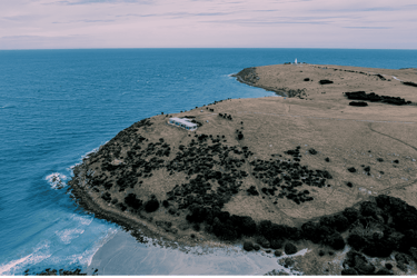 Waves lap onto Pink Bay beach at the foot of one of Sea Dragon Lodge's Luxury Ocean View Retreats on Kangaroo Island
